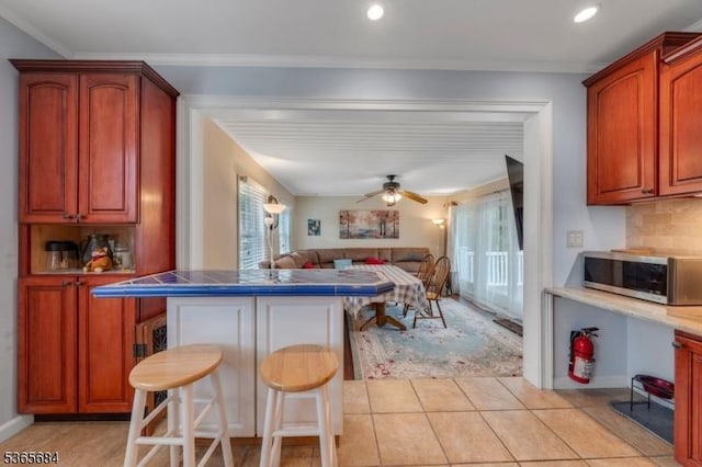 16 Ridgewood Pkwy W, Denville Twp, NJ 07834 - kitchen with stainless steel microwave, a breakfast bar, open floor plan, a peninsula, and decorative backsplash