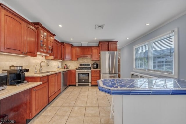 16 Ridgewood Pkwy W, Denville Twp, NJ 07834 - kitchen with stainless steel appliances, tasteful backsplash, under cabinet range hood, light tile patterned floors, and glass insert cabinets