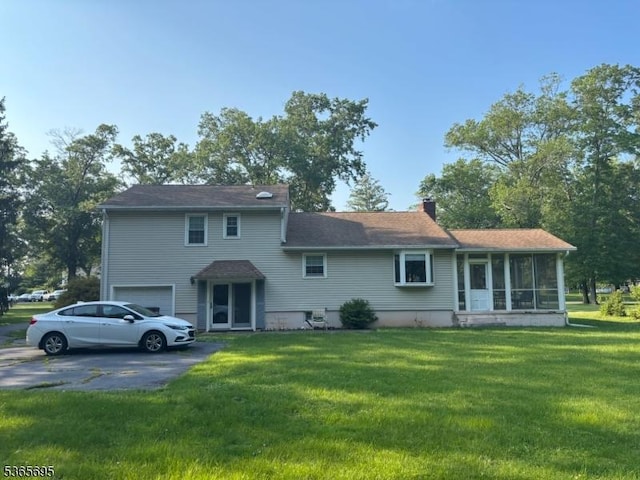 508 Stony Brook Dr, Bridgewater Twp, NJ 08807 - rear view of property with asphalt driveway, a garage, a sunroom, a chimney, and a lawn
