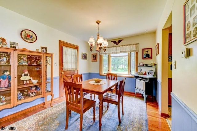 508 Stony Brook Dr, Bridgewater Twp, NJ 08807 - dining area with a chandelier, wainscoting, and light wood finished floors
