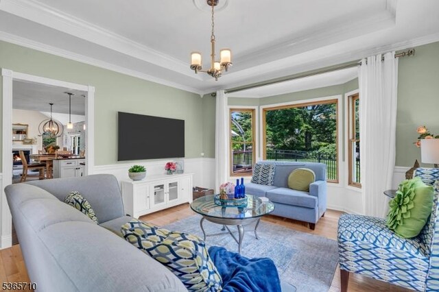 6 White Rd, Raritan Twp, NJ 08822 - living room with a chandelier, crown molding, wood finished floors, a tray ceiling, and a wainscoted wall