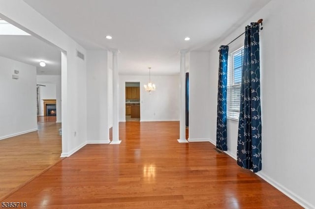 8 Cobblers Cir, Franklin Twp, NJ 08823 - spare room with a chandelier, wood finished floors, recessed lighting, and a warm lit fireplace