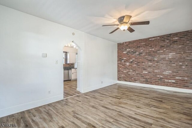 522 Locust Ave, Hillside Twp, NJ 07205 - unfurnished room featuring a ceiling fan, wood finished floors, arched walkways, and brick wall