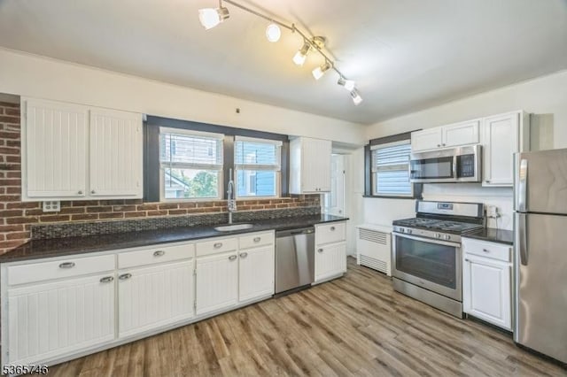 522 Locust Ave, Hillside Twp, NJ 07205 - kitchen with stainless steel appliances, radiator, white cabinets, dark countertops, and light wood finished floors