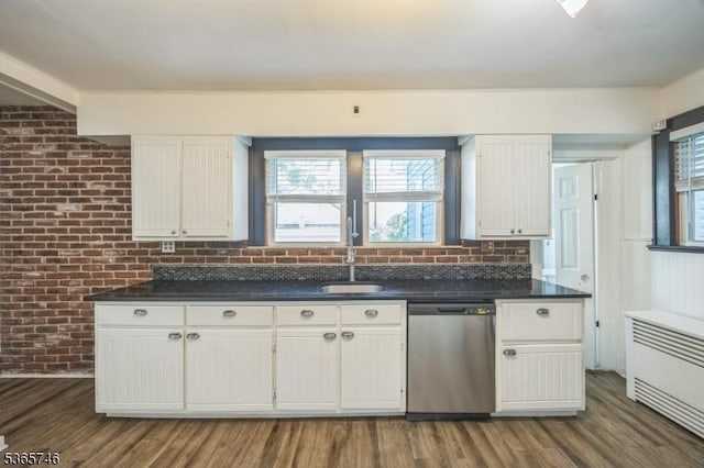 522 Locust Ave, Hillside Twp, NJ 07205 - kitchen with stainless steel dishwasher, white cabinets, dark countertops, dark wood-style flooring, and brick wall