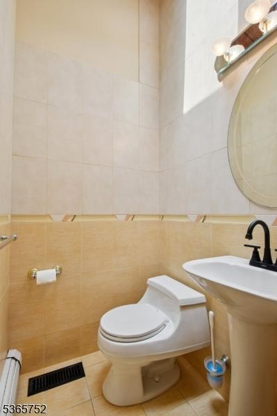 11 Rising Ridge Rd, Upper Saddle River Boro, NJ 07458 - half bathroom featuring tile walls, baseboard heating, and tile patterned flooring