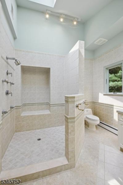 11 Rising Ridge Rd, Upper Saddle River Boro, NJ 07458 - full bath featuring baseboard heating, rail lighting, walk in shower, and tile patterned flooring