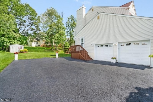 12 Autumn Dr, Mine Hill Twp, NJ 07803 - view of side of home featuring driveway, a yard, a chimney, and a shed