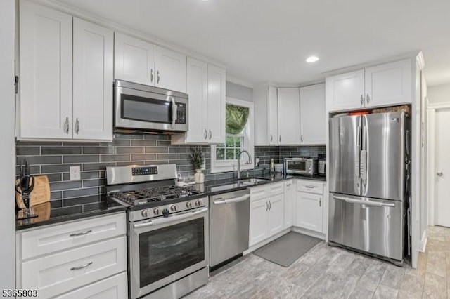 95 Harrison Ave, North Plainfield Boro, NJ 07060 - kitchen featuring stainless steel appliances, white cabinets, tasteful backsplash, recessed lighting, and light wood-type flooring