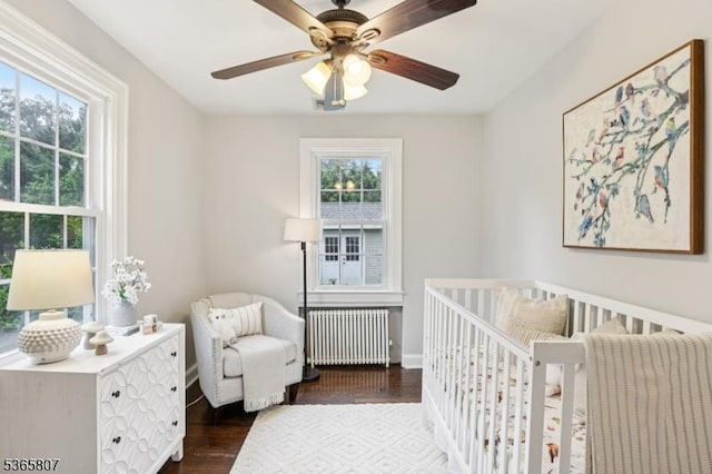 213 Columbia Ave, Cranford Twp, NJ 07016 - bedroom with radiator, multiple windows, a crib, and dark wood-type flooring