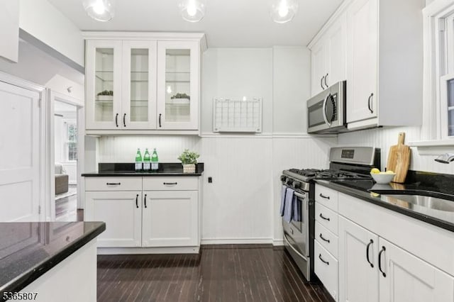 213 Columbia Ave, Cranford Twp, NJ 07016 - kitchen featuring appliances with stainless steel finishes, white cabinetry, glass insert cabinets, dark wood finished floors, and dark stone counters