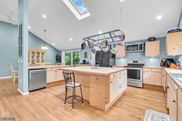 9 Mueller Ln, Franklin Twp, NJ 07882 - kitchen featuring light brown cabinets, appliances with stainless steel finishes, a skylight, a kitchen island, and light wood-style floors