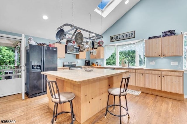 9 Mueller Ln, Franklin Twp, NJ 07882 - kitchen featuring stainless steel appliances, light brown cabinets, a skylight, light countertops, and a kitchen island