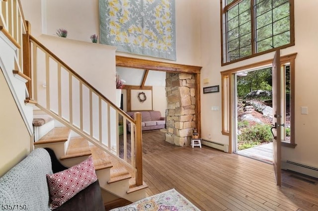 134 Milton Rd, Sparta Twp, NJ 07871 - entryway with a towering ceiling, baseboard heating, hardwood / wood-style floors, and stairs