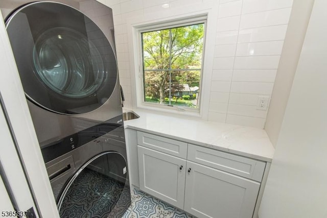 157 Meyersville Rd, Chatham Twp, NJ 07928 - laundry area with stacked washing machine and dryer, cabinet space, and light tile patterned floors