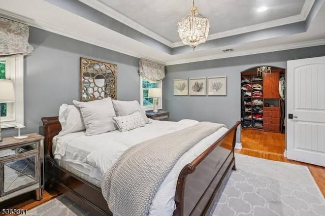 27 Wesley Ct, New Providence Boro, NJ 07974 - bedroom featuring wood finished floors, crown molding, a chandelier, a raised ceiling, and arched walkways
