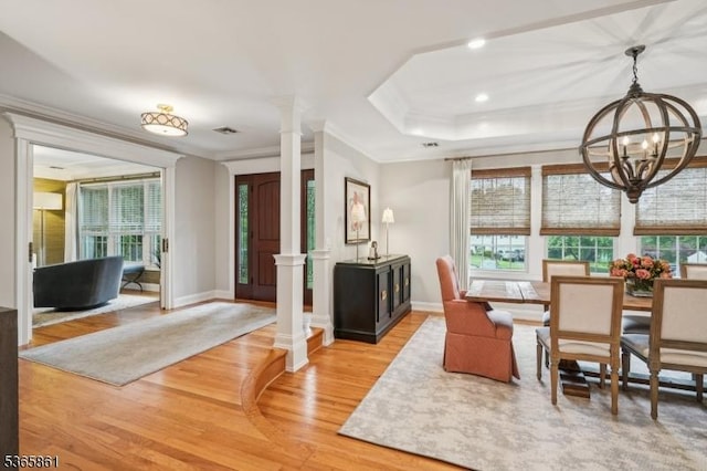 27 Wesley Ct, New Providence Boro, NJ 07974 - dining area featuring ornate columns, a chandelier, light wood finished floors, crown molding, and plenty of natural light