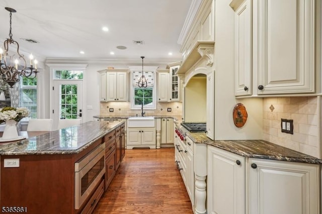 27 Wesley Ct, New Providence Boro, NJ 07974 - kitchen with stainless steel appliances, a chandelier, ornamental molding, dark stone counters, and backsplash