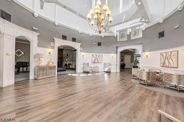 7108 Ravenscroft Rd Unit 7108, Clifton City, NJ 07013 - living area with a high ceiling, arched walkways, a chandelier, light wood-type flooring, and a decorative wall