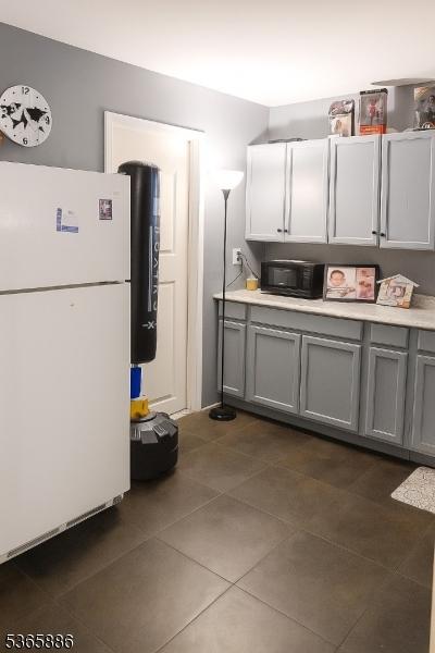 452 W 4th Ave, Roselle Boro, NJ 07203 - kitchen featuring freestanding refrigerator, gray cabinetry, dark tile patterned floors, and light countertops