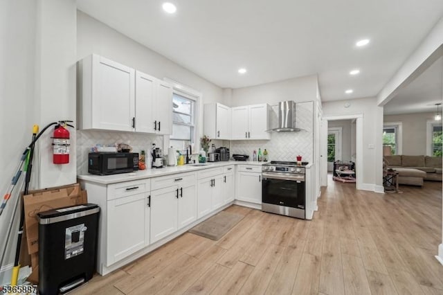62 Rt46, Mine Hill Twp, NJ 07803 - kitchen with stainless steel range oven, wall chimney exhaust hood, black microwave, backsplash, and white cabinets