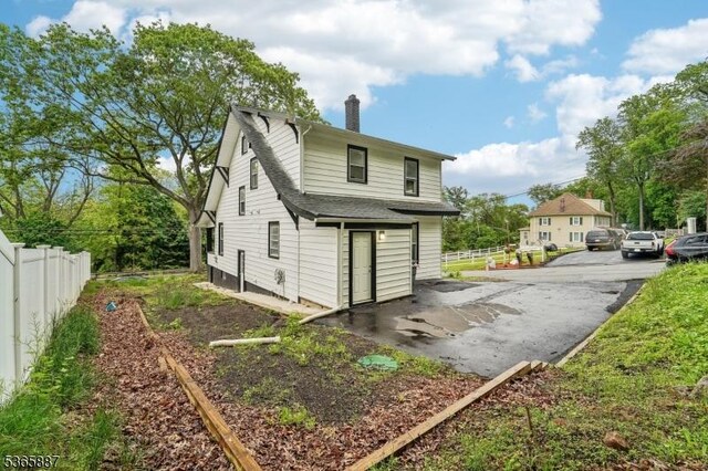 62 Rt46, Mine Hill Twp, NJ 07803 - back of property featuring a chimney, a shingled roof, and a patio