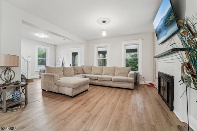 62 Rt46, Mine Hill Twp, NJ 07803 - living room with radiator, light wood-style flooring, a glass covered fireplace, and stairway