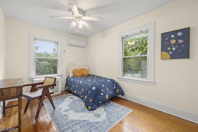 72 Meadowbrook Rd, Millburn Twp, NJ 07078 - bedroom featuring a wall unit AC, multiple windows, hardwood / wood-style flooring, and a ceiling fan