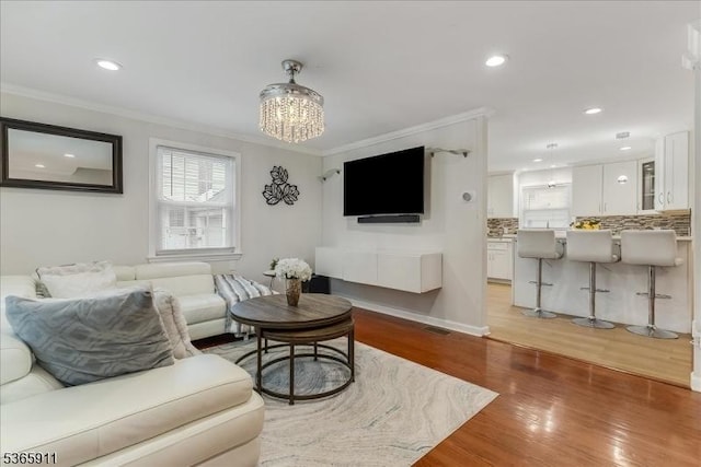 1592 Front St, Scotch Plains Twp, NJ 07076 - living room with plenty of natural light, ornamental molding, light wood-style flooring, a chandelier, and recessed lighting