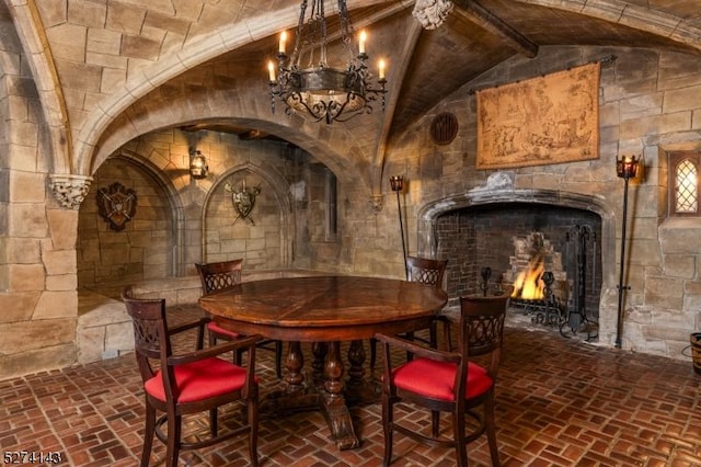 12 Canfield Rd, Morris Twp, NJ 07960 - wine area with brick flooring, a lit fireplace, and a chandelier
