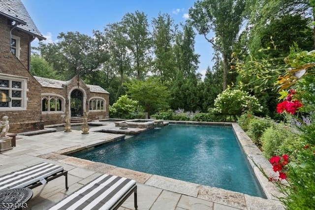 12 Canfield Rd, Morris Twp, NJ 07960 - view of pool featuring a patio area, a pool with connected hot tub, and view of wooded area