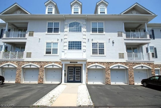 10 Cliff Rd Unit A3, Woodland Park, NJ 07424 - view of front facade featuring driveway, an attached garage, stucco siding, and french doors