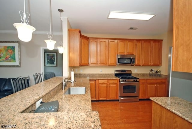 10 Cliff Rd Unit A3, Woodland Park, NJ 07424 - kitchen featuring stainless steel appliances, light stone countertops, wood finished floors, crown molding, and hanging light fixtures