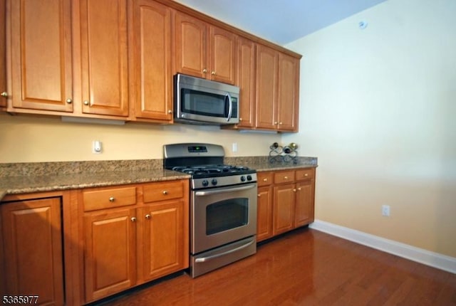 10 Cliff Rd Unit A3, Woodland Park, NJ 07424 - kitchen featuring stainless steel appliances, dark wood finished floors, dark stone counters, and brown cabinets