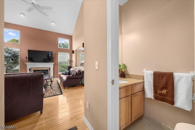 18 Running Brook Cir, Raritan Twp, NJ 08822 - bathroom with a ceiling fan, vanity, a fireplace, high vaulted ceiling, and wood finished floors