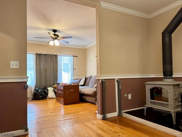 77 Belvidere Ave, Oxford Twp, NJ 07863 - living area featuring a wood stove, a ceiling fan, light wood-style floors, and ornamental molding