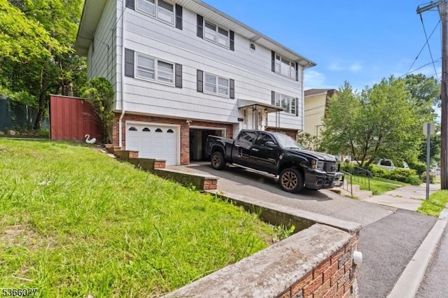 132 N 17th St, Prospect Park Boro, NJ 07508 - view of front of home with brick siding, an attached garage, driveway, and a front lawn