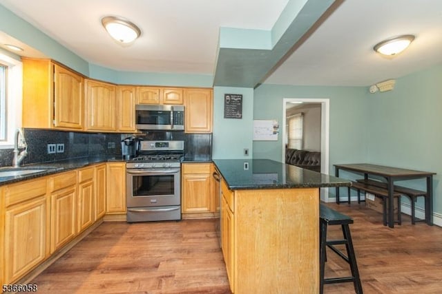 19 Card St, Hamburg Boro, NJ 07419 - kitchen featuring appliances with stainless steel finishes, a kitchen breakfast bar, tasteful backsplash, wood finished floors, and light brown cabinetry