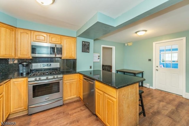 19 Card St, Hamburg Boro, NJ 07419 - kitchen featuring appliances with stainless steel finishes, a peninsula, tasteful backsplash, and wood finished floors
