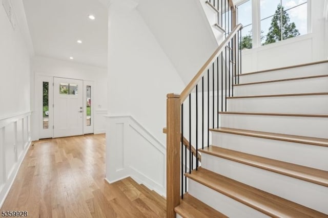 151 Center Ave, Chatham Boro, NJ 07928 - foyer entrance with a decorative wall, healthy amount of natural light, light wood-type flooring, stairway, and a wainscoted wall