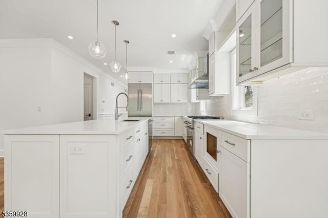 151 Center Ave, Chatham Boro, NJ 07928 - kitchen featuring wall chimney exhaust hood, light wood-style floors, white cabinets, backsplash, and a center island with sink