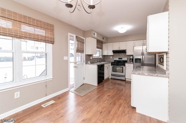 167 Riva Dr, Mansfield Twp, NJ 07840 - kitchen featuring stainless steel appliances, under cabinet range hood, a chandelier, light wood-style flooring, and backsplash