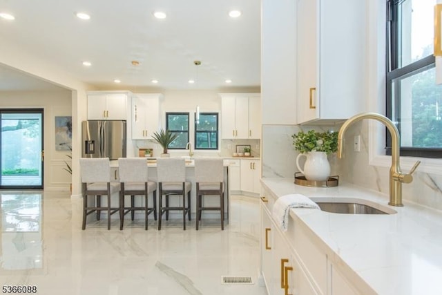 24 Hillcrest Rd, Mountain Lakes Boro, NJ 07046 - kitchen with stainless steel refrigerator with ice dispenser, tasteful backsplash, white cabinetry, recessed lighting, and a kitchen bar