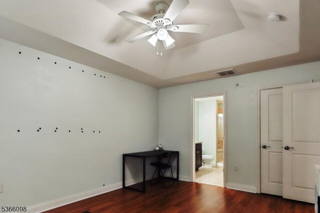 28 Elston Ct Unit 28, Wanaque Boro, NJ 07420 - unfurnished bedroom with a tray ceiling, wood finished floors, connected bathroom, and ceiling fan