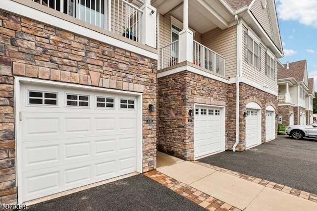 28 Elston Ct Unit 28, Wanaque Boro, NJ 07420 - view of side of home with stone siding, an attached garage, and driveway