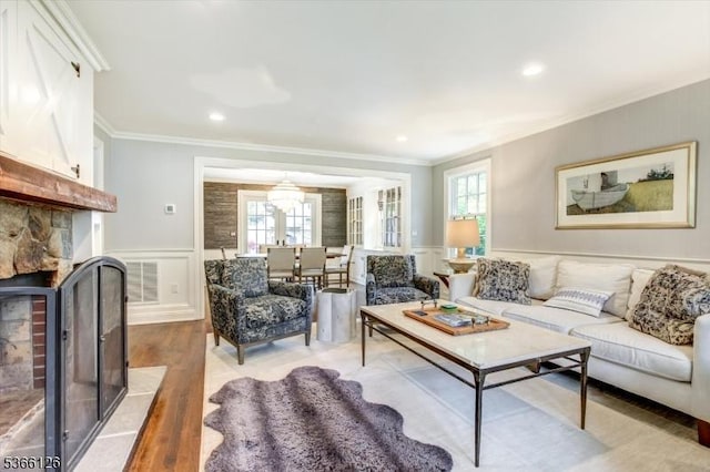 109 Chatham St, Chatham Boro, NJ 07928 - living area with crown molding, light wood-style flooring, a fireplace with flush hearth, wainscoting, and healthy amount of natural light