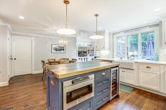 109 Chatham St, Chatham Boro, NJ 07928 - kitchen featuring wine cooler, stainless steel microwave, dark wood finished floors, crown molding, and white cabinets