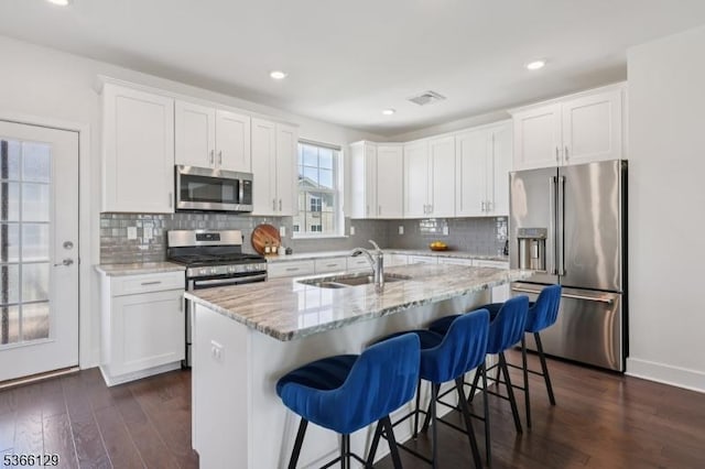 12 Colgate Dr, Morris Twp, NJ 07960 - kitchen with appliances with stainless steel finishes, white cabinetry, dark wood-style flooring, light stone countertops, and recessed lighting