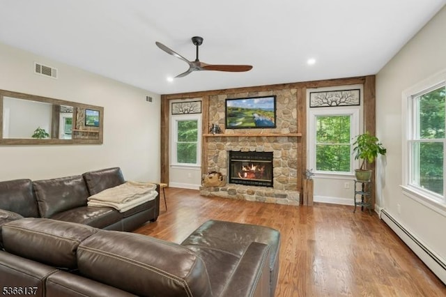 4 Knollwood Ln, Hardyston Twp, NJ 07460 - living area with a baseboard heating unit, a ceiling fan, a stone fireplace, wood finished floors, and recessed lighting