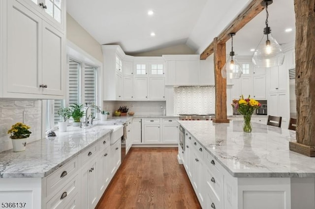 4 Knollwood Ln, Hardyston Twp, NJ 07460 - kitchen featuring a spacious island, lofted ceiling, white cabinets, wood finished floors, and backsplash